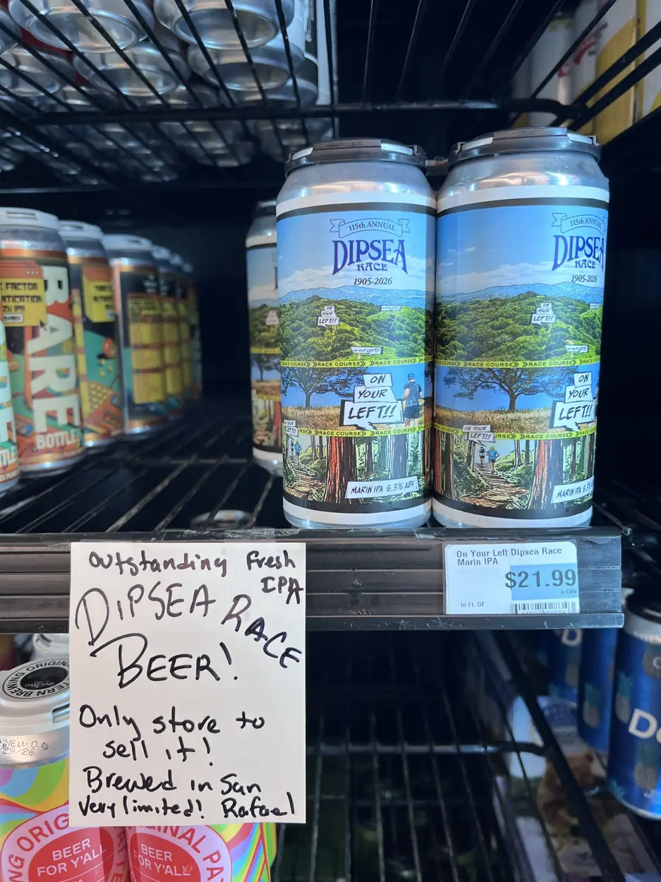 Dipsea Race On Your Left Marin IPA cans with illustrated race labels in a shop refrigerator